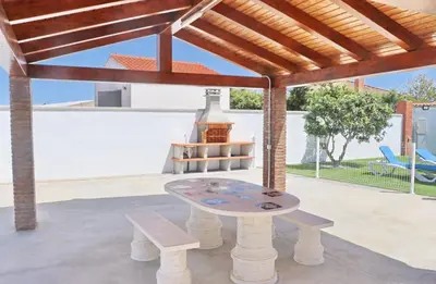 a patio with a table and benches under a pavilion at Alojamiento Rural Las Quintas in Conil de la Frontera