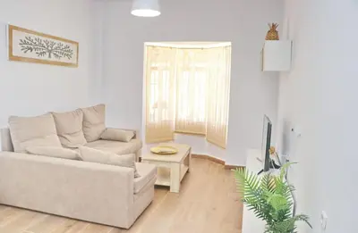 a living room with a couch and a chair at Alojamiento Rural Las Quintas in Conil de la Frontera