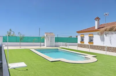a swimming pool in a yard next to a house at Alojamiento Rural Las Quintas in Conil de la Frontera