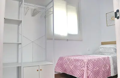 a white bedroom with a bed and a window at Alojamiento Rural Las Quintas in Conil de la Frontera