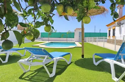 two blue and white chairs sitting next to a pool at Alojamiento Rural Las Quintas in Conil de la Frontera