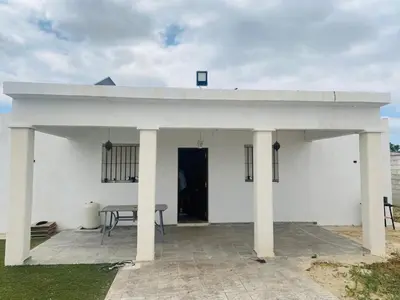 a white house with a table on a patio at Villa Eterno in Chiclana de la Frontera