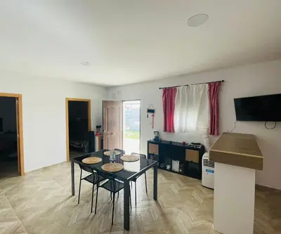 a living room with a table and chairs and a television at Villa Eterno in Chiclana de la Frontera