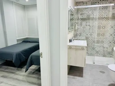 a bedroom with a bed and a bathroom with a sink at El Corner de Esquivel Grupo AC Gestion in Cádiz