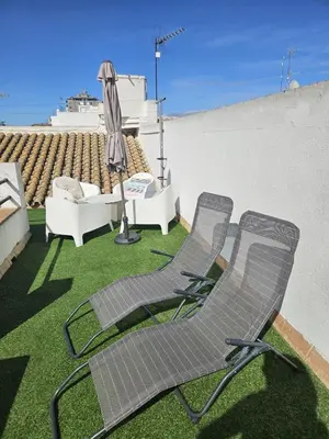 two lawn chairs and an umbrella on a roof at Precioso Ático de Lujo en Calle Ancha in Sanlúcar de Barrameda