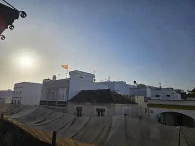 a group of white buildings with the sun in the background at Precioso Ático de Lujo en Calle Ancha in Sanlúcar de Barrameda