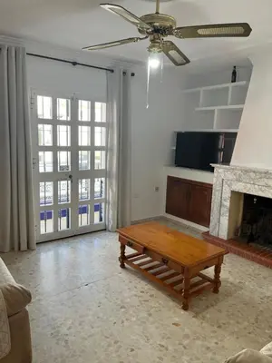 a living room with a coffee table and a fireplace at Casa MAC in Chiclana de la Frontera