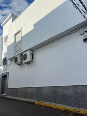 a white building with a balcony on the side of it at Casa MAC in Chiclana de la Frontera