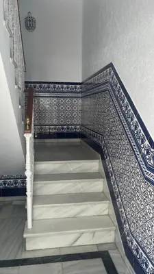 a staircase with blue and white tiled walls at Casa MAC in Chiclana de la Frontera