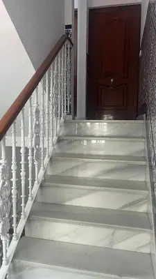 a stairwell with white stairs and a wooden door at Casa MAC in Chiclana de la Frontera