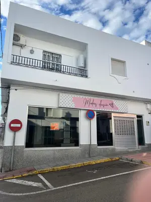 a white building with a pink sign on it at Casa MAC in Chiclana de la Frontera