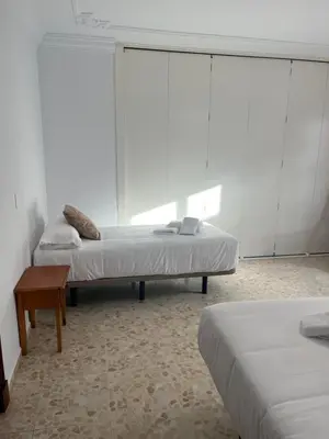 a room with two beds and a table in it at Casa MAC in Chiclana de la Frontera