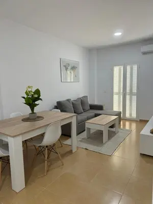 a living room with a table and a couch at Piso Centro Chiclana in Chiclana de la Frontera