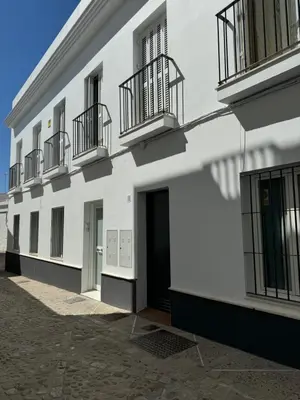 a white building with balconies on the side of it at Piso Centro Chiclana in Chiclana de la Frontera
