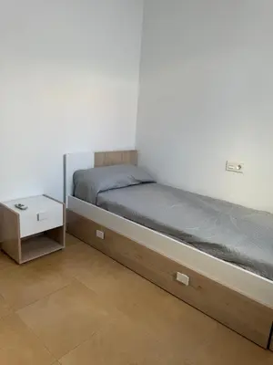 a bedroom with a bed and a night stand at Piso Centro Chiclana in Chiclana de la Frontera