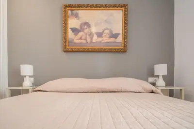 a bedroom with a bed and a painting on the wall at Kotinousa Cádiz - Centro historico in Cádiz