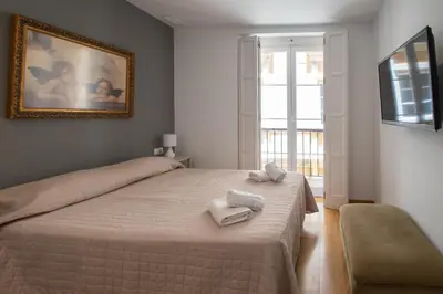 a bedroom with a bed with two towels on it at Kotinousa Cádiz - Centro historico in Cádiz