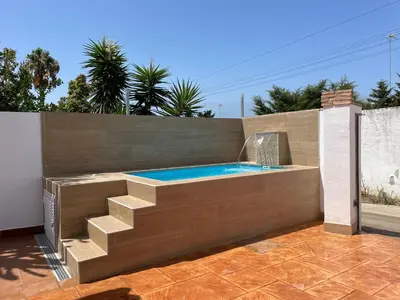 a swimming pool with a staircase and a swimming poolvisor at Casita Kairós in Conil de la Frontera