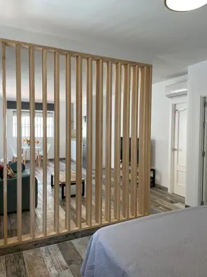 a room with a wall of vertical wooden bars at Casita Kairós in Conil de la Frontera