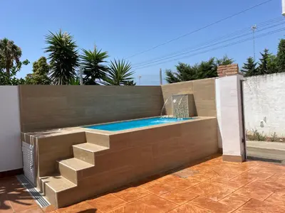 a swimming pool with a staircase and a fountain at Casita Kairós in Conil de la Frontera