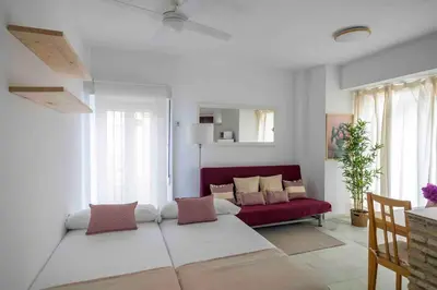 a living room with a couch and a red couch at GINVA - MMS Bounty Puerto Sherry Playa in El Puerto de Santa María