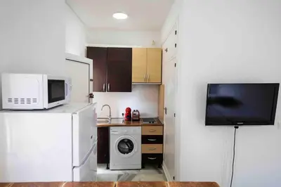 a small kitchen with a microwave and a refrigerator at GINVA - MMS Bounty Puerto Sherry Playa in El Puerto de Santa María