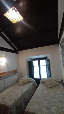 a bedroom with two beds and a window at Duplex convento la victoria in Sanlúcar de Barrameda