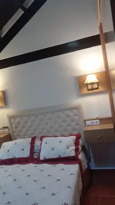 a bedroom with a bed with red and white pillows at Duplex convento la victoria in Sanlúcar de Barrameda