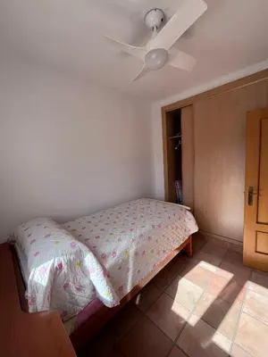 a bedroom with a bed with a ceiling fan at Adosado con jardín Urb Galia Ballena in Cádiz