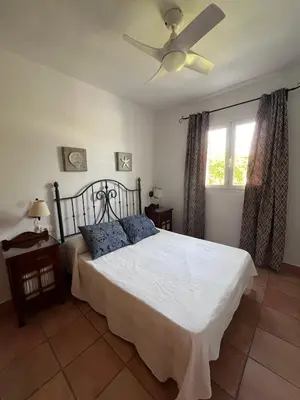 a bedroom with a bed and a ceiling fan at Adosado con jardín Urb Galia Ballena in Cádiz