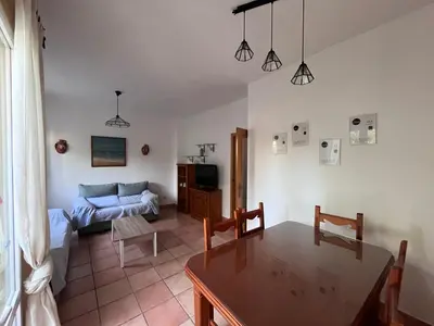 a living room with a table and a couch at Adosado con jardín Urb Galia Ballena in Cádiz