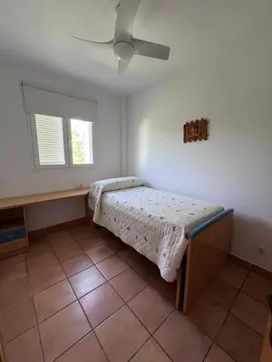 a bedroom with a bed and a ceiling fan at Adosado con jardín Urb Galia Ballena in Cádiz