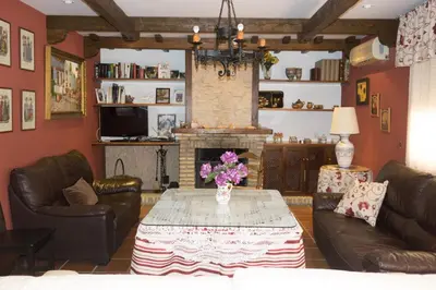 a living room with a table and a fireplace at Chalet Enol Sol in Chiclana de la Frontera