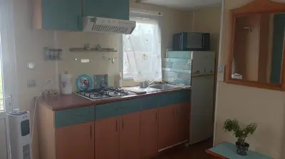 a small kitchen with a sink and a refrigerator at La Vida el Verano en Novo Sancti Petri - Casa Acogedora in Chiclana de la Frontera