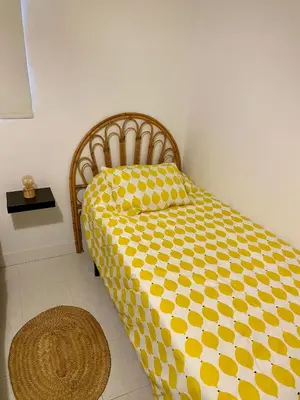 a bedroom with a yellow and white comforter on a bed at Casa Rural La Yeguada in Malcocinado