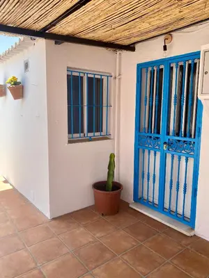 a house with a blue door and a cactus next to it at Casa Rural La Yeguada in Malcocinado