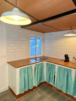 a kitchen with blue and white counters and windows at Casa Rural La Yeguada in Malcocinado