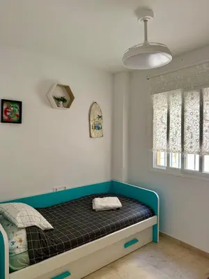 a bedroom with a bed in a room with a window at Chipiona - Playa a 200m terraza piscina padel in Chipiona