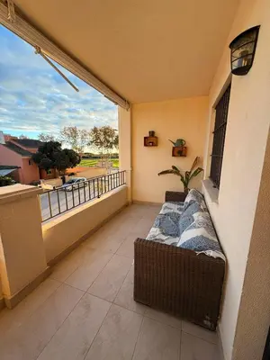 a balcony with a bed and a large window at Chipiona - Playa a 200m terraza piscina padel in Chipiona