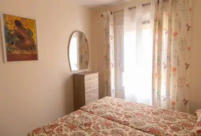 a bedroom with a bed and a dresser and a window at El Ático del Olivarillo in San Fernando