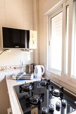 a kitchen with a stove and a window at El Ático del Olivarillo in San Fernando