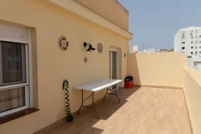 a balcony with a table on the side of a building at El Ático del Olivarillo in San Fernando