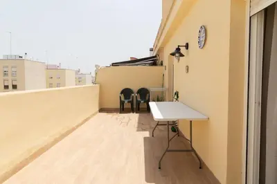 a room with a table and chairs on a balcony at El Ático del Olivarillo in San Fernando