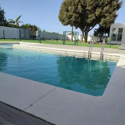 a swimming pool with blue water in a park at Habitación en el centro de bienestar TFM in Cádiz