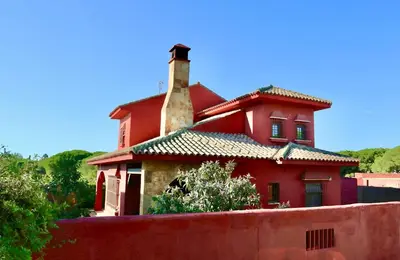 a red house with a chimney on top of it at Chalet independiente en la loma in Chiclana de la Frontera