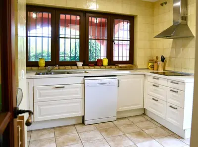 a kitchen with white cabinets and a sink and windows at Chalet independiente en la loma in Chiclana de la Frontera