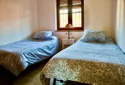 a bedroom with two beds and a window at Chalet independiente en la loma in Chiclana de la Frontera