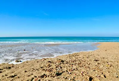 a beach with rocks and the ocean on a sunny day at Chalet independiente en la loma in Chiclana de la Frontera