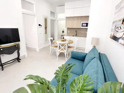 a living room with a blue couch and a table at Apartamento Infantas 26 in Sanlúcar de Barrameda