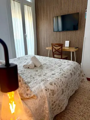 a living room with two chairs and a table with a lamp at Hostal El Faro in Chipiona
